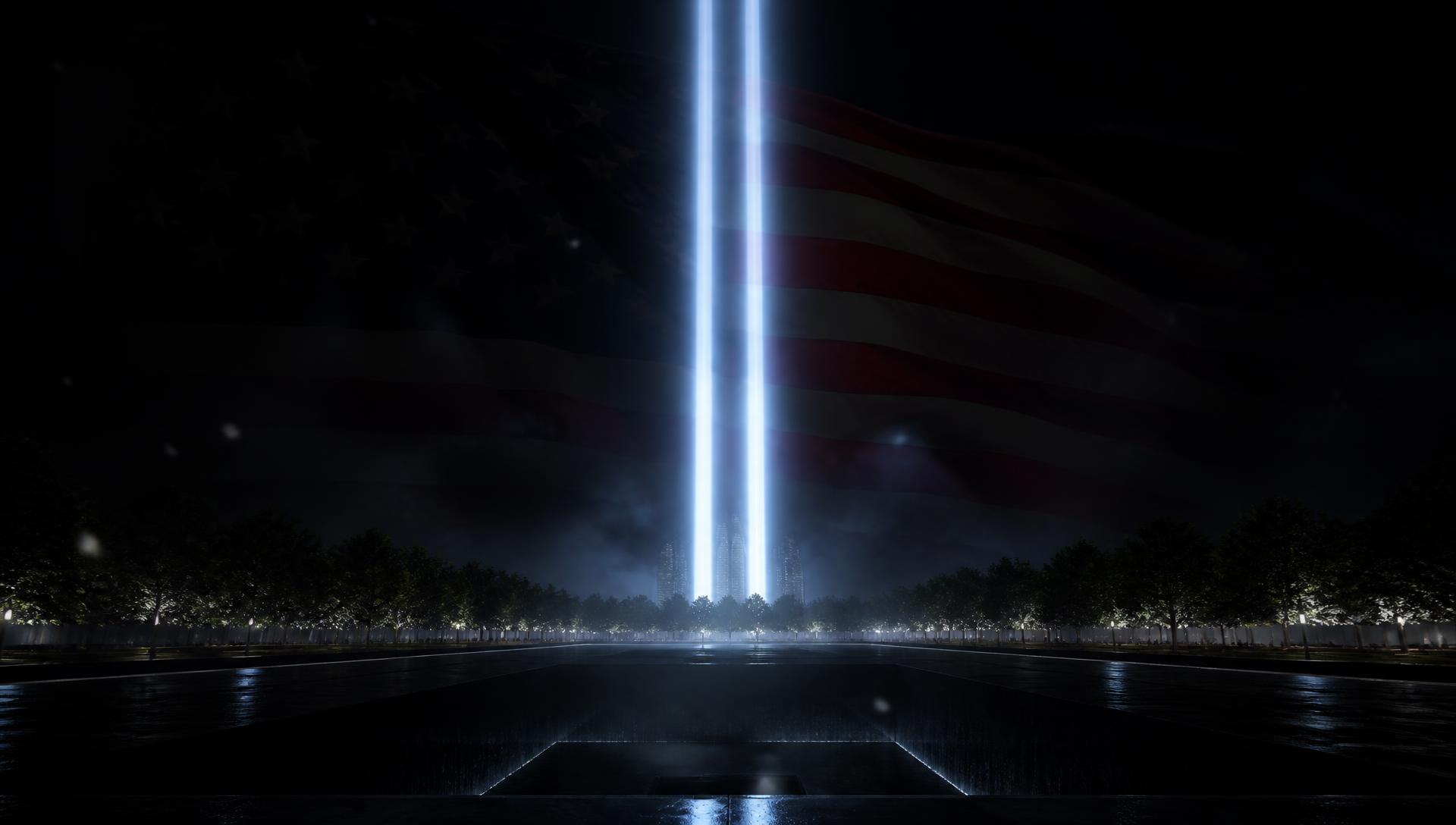 Two beams of white light rising above a memorial plaza at night with an American flag behind